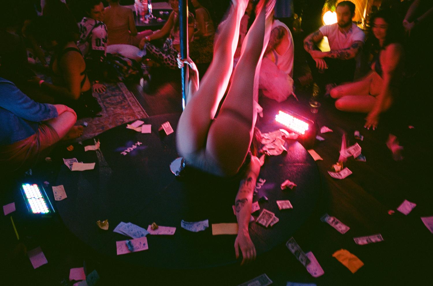 Angel Bills and dollar bills scattered around the pole stage